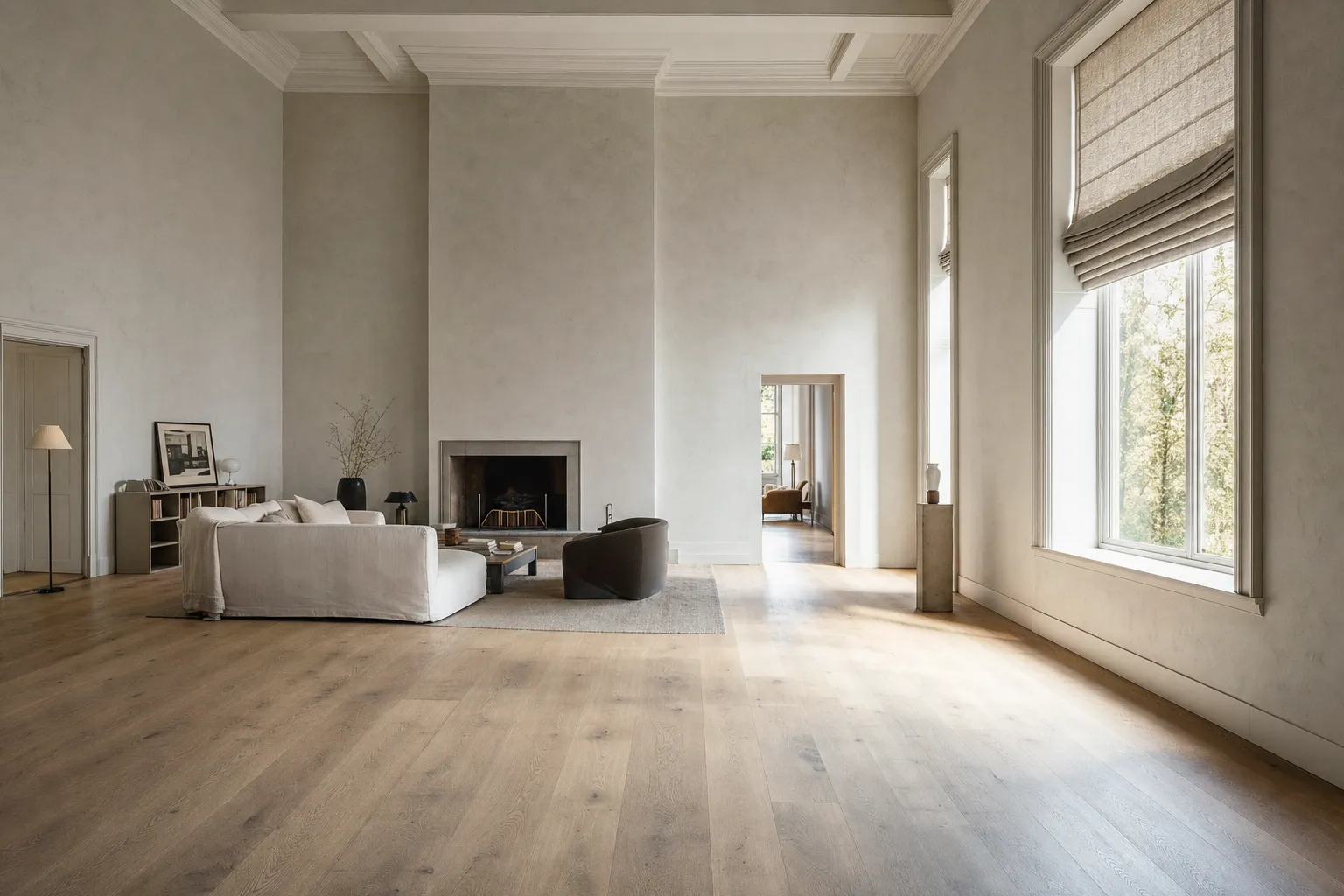 A wide, bright room with tall windows on the right, a roman shade raised so its linen gathers into stacked horizontal folds above the glass, seen from across an empty oak floor